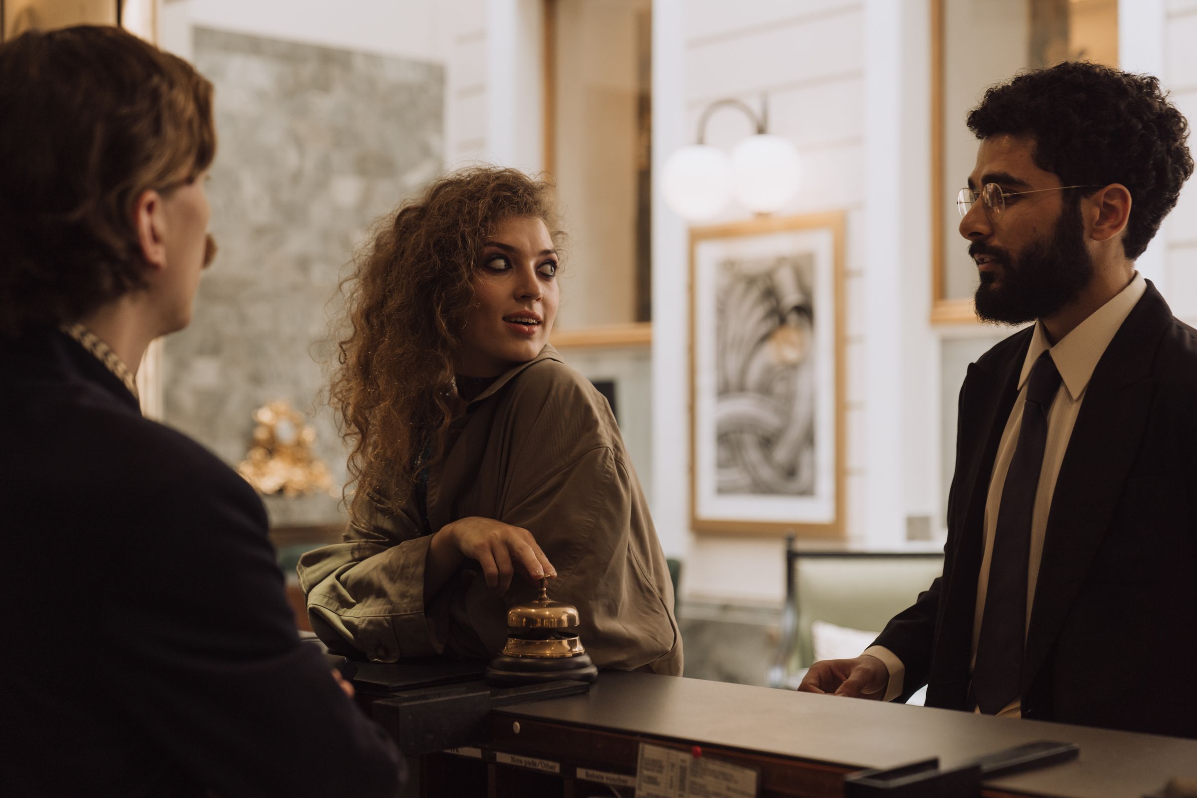 A hospitality professional assisting guests at a hotel reception